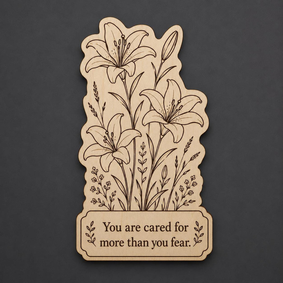 Front close-up of Lily Wood Plaque You Are Cared For Quote Sign Floral Birch Wall Art With Desk, showing dark engraving on natural birch wood.