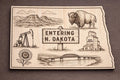 Front close-up of North Dakota Wood Wall Art State Welcome Sign Birch Decor, showing dark engraving on natural birch wood.