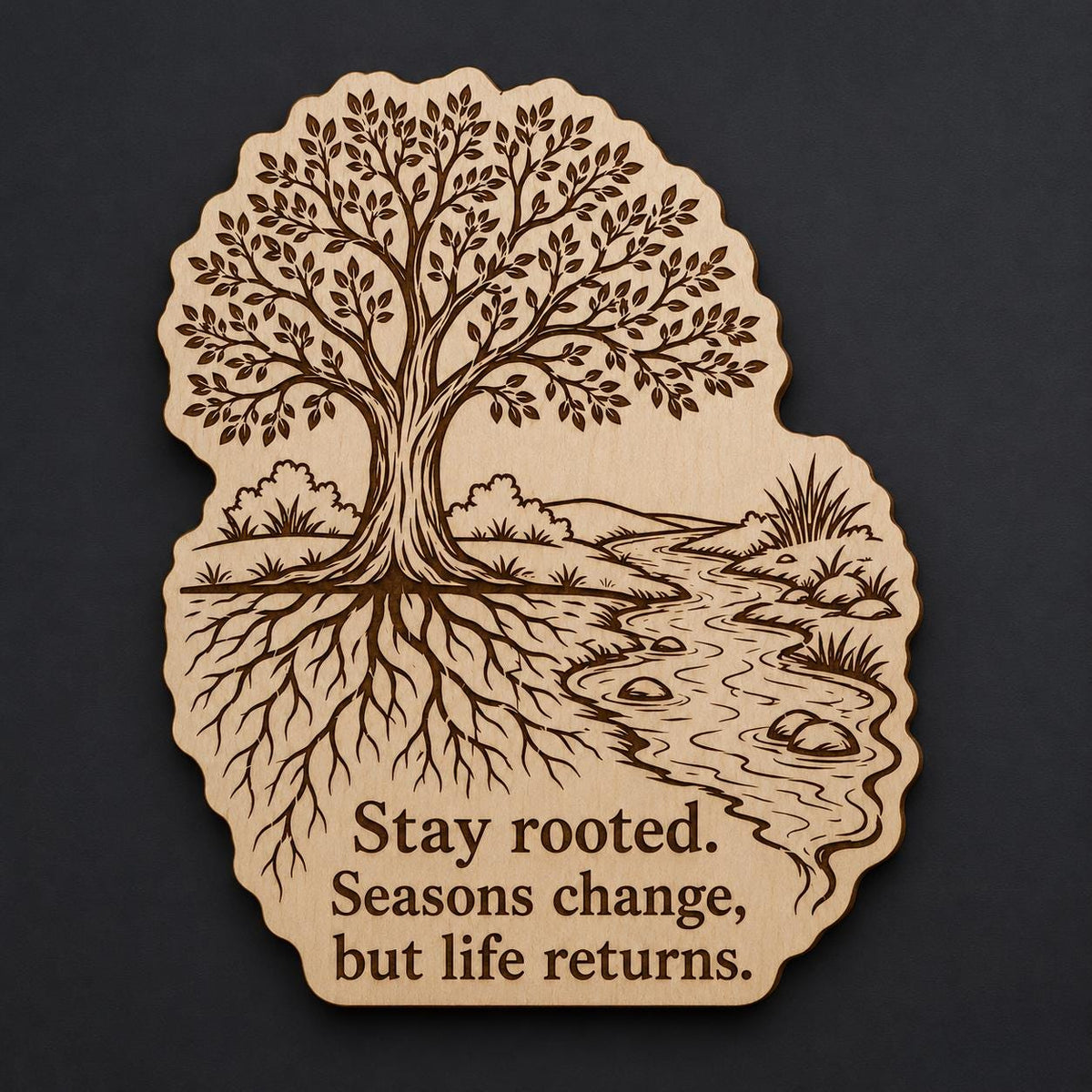 Front close-up of Tree Wood Plaque Stay Rooted Quote Sign Inspirational Birch Wall Art With Stream and Roots, showing dark engraving on natural birch wood.