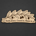 Front close-up of Olive Branch Wood Plaque Seek Peace Quote Sign Long Birch Wall Art With Natural Branch, showing dark engraving on natural birch wood.
