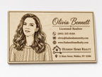 Close front view of a personalized engraved birch realtor card with portrait and contact details.