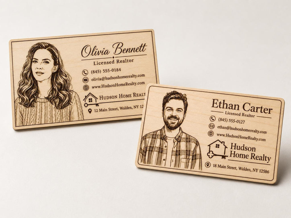 Two personalized engraved birch business cards with portraits, logos, and contact details on a neutral surface.