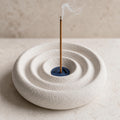 Close-up of the textured Stillwave incense holder in Coastal Fog with a smoking incense stick
