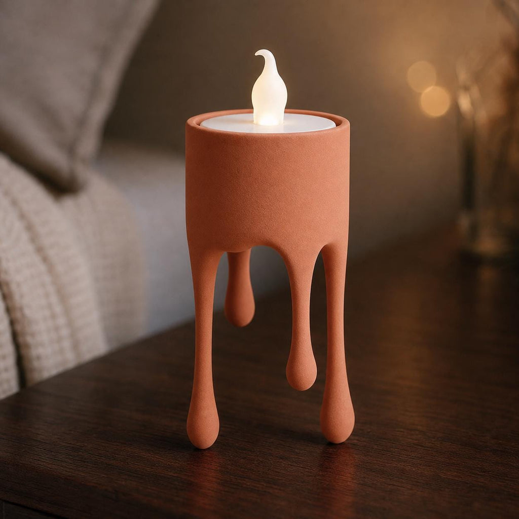 Terracotta HoverDrip flameless tealight holder glowing on a bedside table