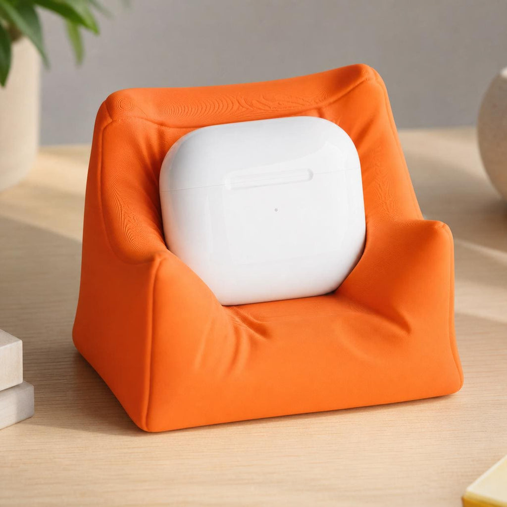 Close-up of the Mandarin Orange PillowPod earbud stand on a creative desk