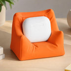 Close-up of the Mandarin Orange PillowPod earbud stand on a creative desk