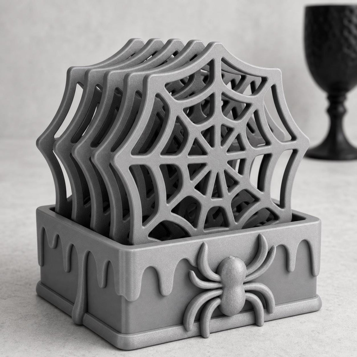 Bright studio close-up of the complete Silver WebWarden holder with all five spiderweb coasters