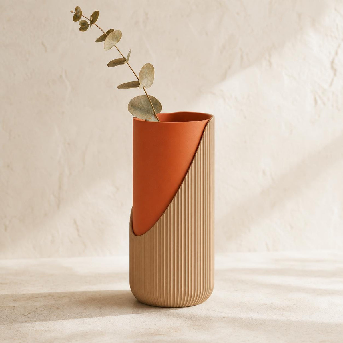Curveveil ribbed vase in the Desert Ember matte colorway with one eucalyptus stem