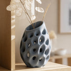 Close-up of the Lacuna Bloom sculptural vase in Blue Grey with pale lunaria stems