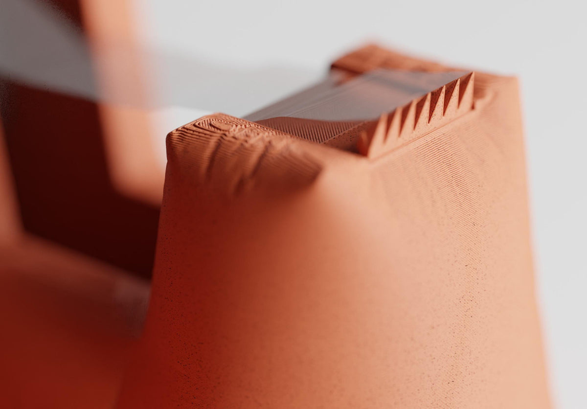Close-up of a DrapeCut tape dispenser in Terracotta showing its softly folded surface detail