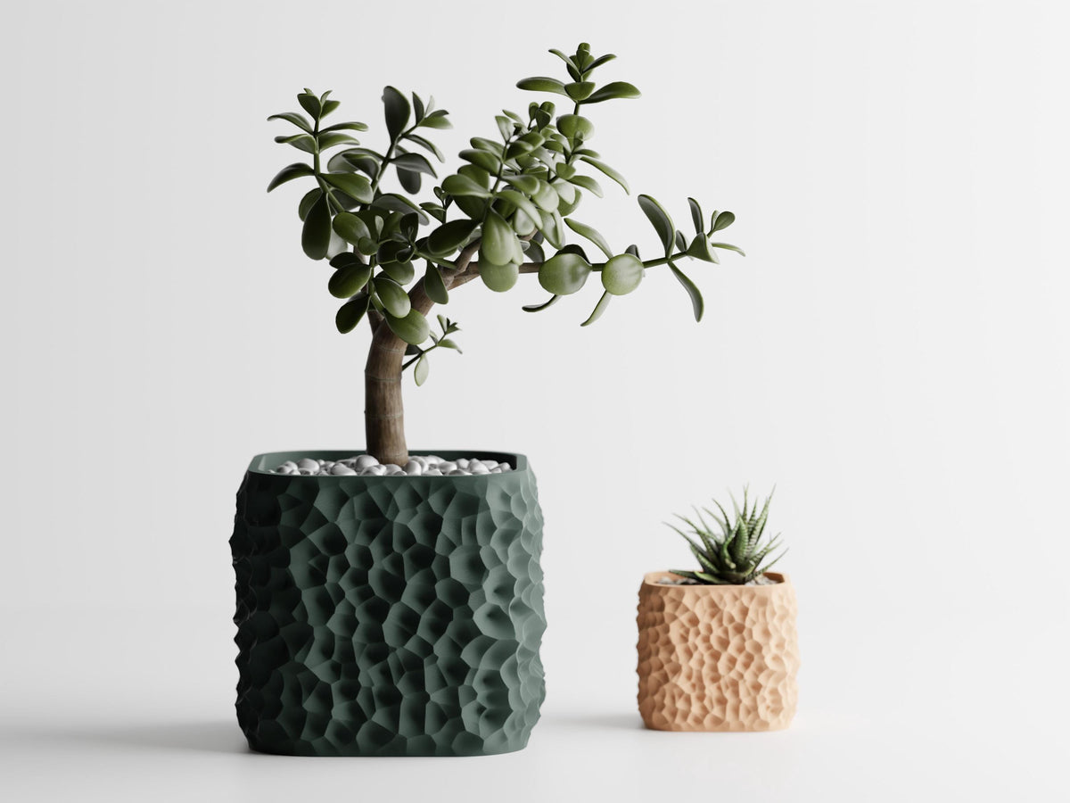 StoneCell sculptural planters in dark green and warm tan finishes with indoor plants
