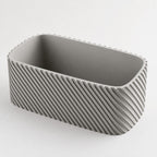 Ash Gray Driftline planter showing the diagonal ribs, rounded corner, rim, and interior