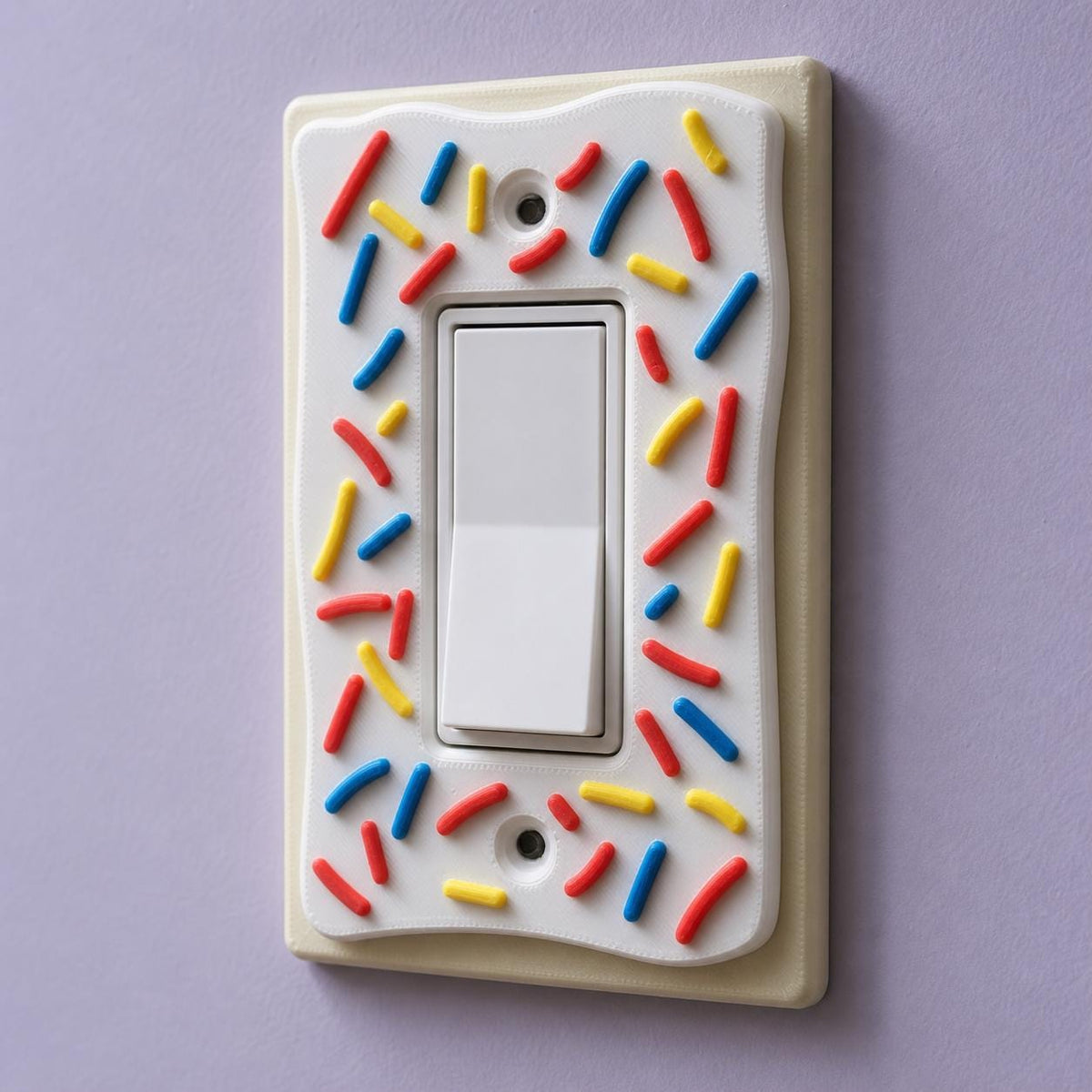 Angled close-up of the Decora rocker SprinkleCrust plate and its raised frosting and sprinkles
