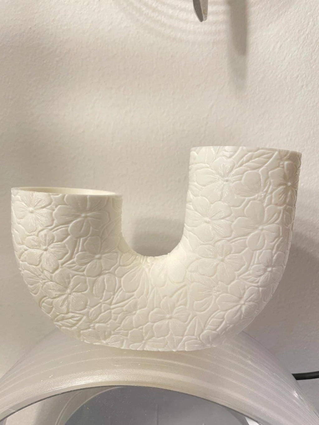 Angled lifestyle view of the Garden Blossoms BloomArc twin vase showing its connected U-shaped silhouette