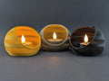 Three TideNest ripple holders in yellow gray and charcoal with warm LED tea lights