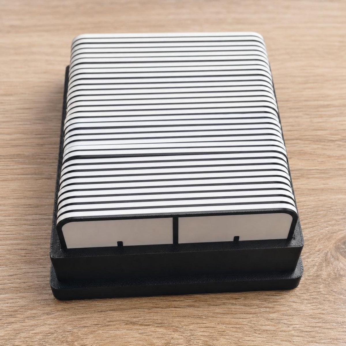 Full EqualLink tile set stacked neatly inside the black organizer tray in a close elevated view on a wood table.