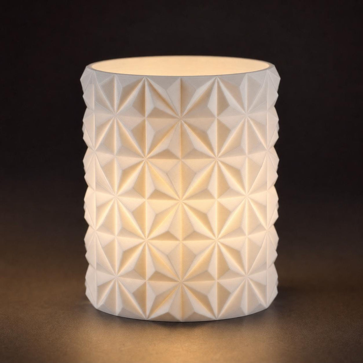 Close-up of the PrismGlow geometric LED tealight sleeve in White with a warm internal glow