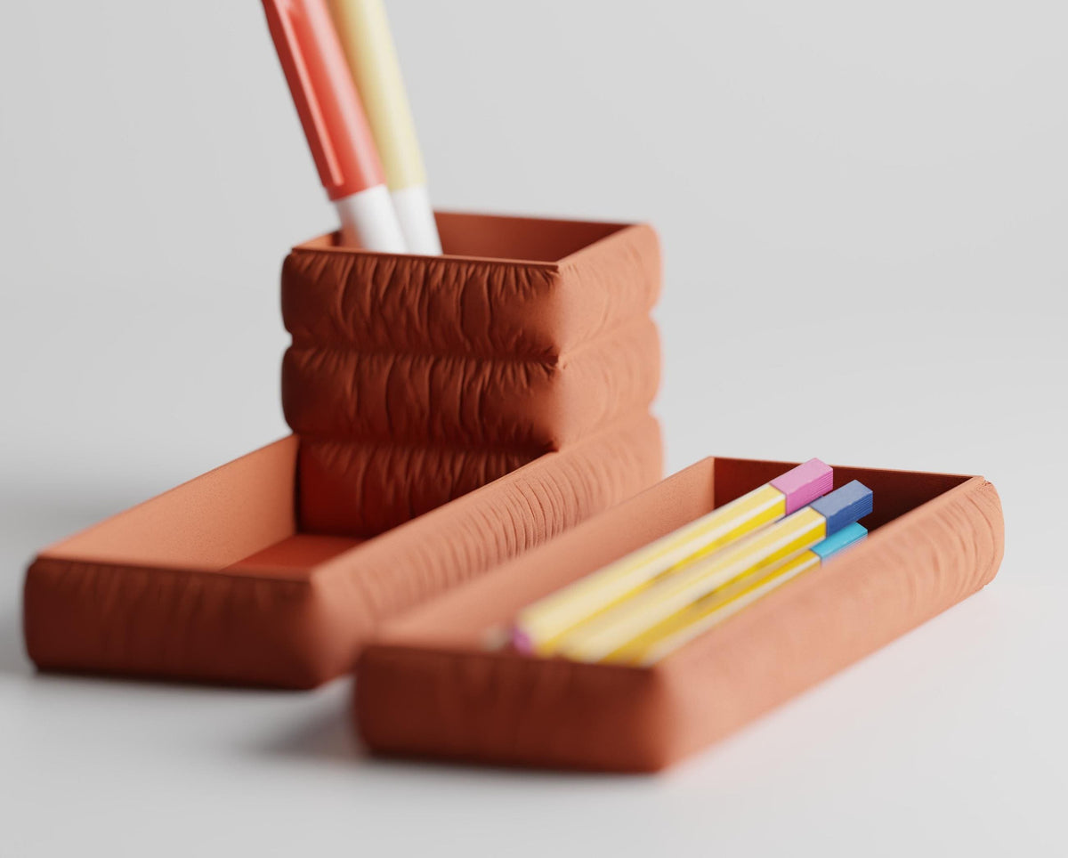 Front-angle close-up of the GatherFold pen cup and pencil tray set in Terracotta