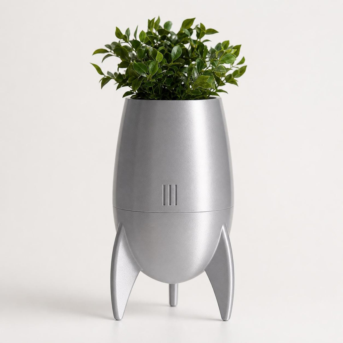Close-up of the NovaPod capsule planter in Silk Silver with a leafy green plant