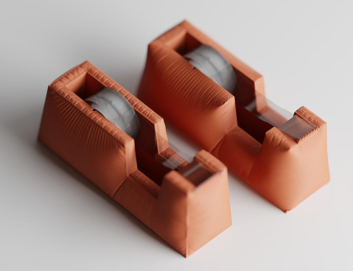 High-angle close-up of two complete DrapeCut tape dispenser silhouettes in Terracotta