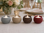 Four VowGlow patterned LED tealight holders in Ash Gray, Desert Tan, Dark Brown, and Dark Red on a wedding reception table