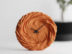FoldWhirl sculptural wall clock in orange with flowing folded texture
