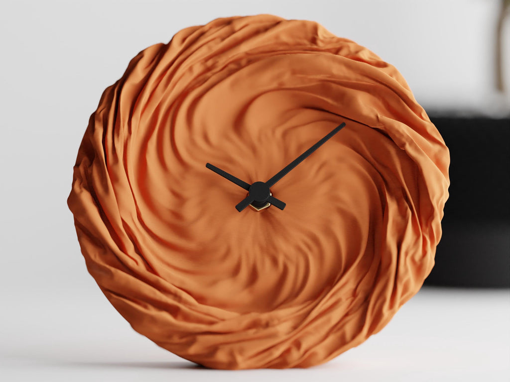 Front close-up of the orange FoldWhirl sculptural wall clock