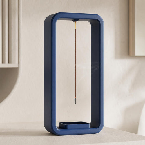 Close-up of a Cobalt Blue AeroCinder suspended incense stand on a warm neutral shelf