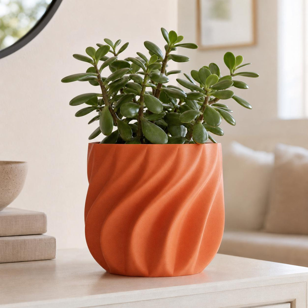 Pumpkin Orange CurrentFold sculptural planter with a jade plant on a modern console