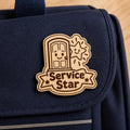 Bright Door Service Star engraved birch reward badge shown close up in a realistic ministry setting.