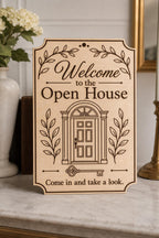 BotanicalEntry engraved birch open-house welcome sign upright on a refined console with a formal door and leafy branches.