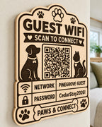 Paws & Connect Guest WiFi Sign engraved birch sign mounted on a realistic neutral interior wall from a close side angle in natural birch and dark engraving, showing the QR code and guest network details.