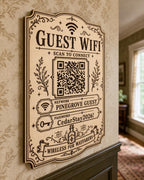 Wayfarer Wireless Guest WiFi Sign engraved birch sign mounted on a realistic neutral interior wall from a close side angle in natural birch and dark engraving, showing the QR code and guest network details.