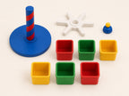 Separated view of the Primary Parade round base, spiral pillar, six-spoke center, six cups, and top cap on a plain background.