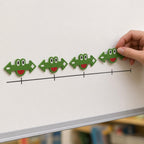 Adult teacher placing one of four green frog math markers above an unlabeled tick line on a classroom whiteboard.