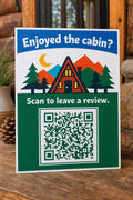 A-Frame Haven multicolor cabin guest review sign upright on a mountain-rental console with a finished sample QR code.
