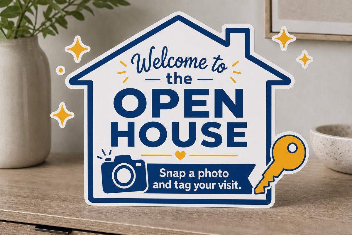 SnapKey multicolor landscape open-house photo sign upright on a light console with a camera, key, and tag-your-visit message.