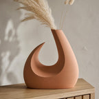MoonGate Statement Vase, close-up lifestyle view of the Solstice Arc vase in Terracotta with dried stems