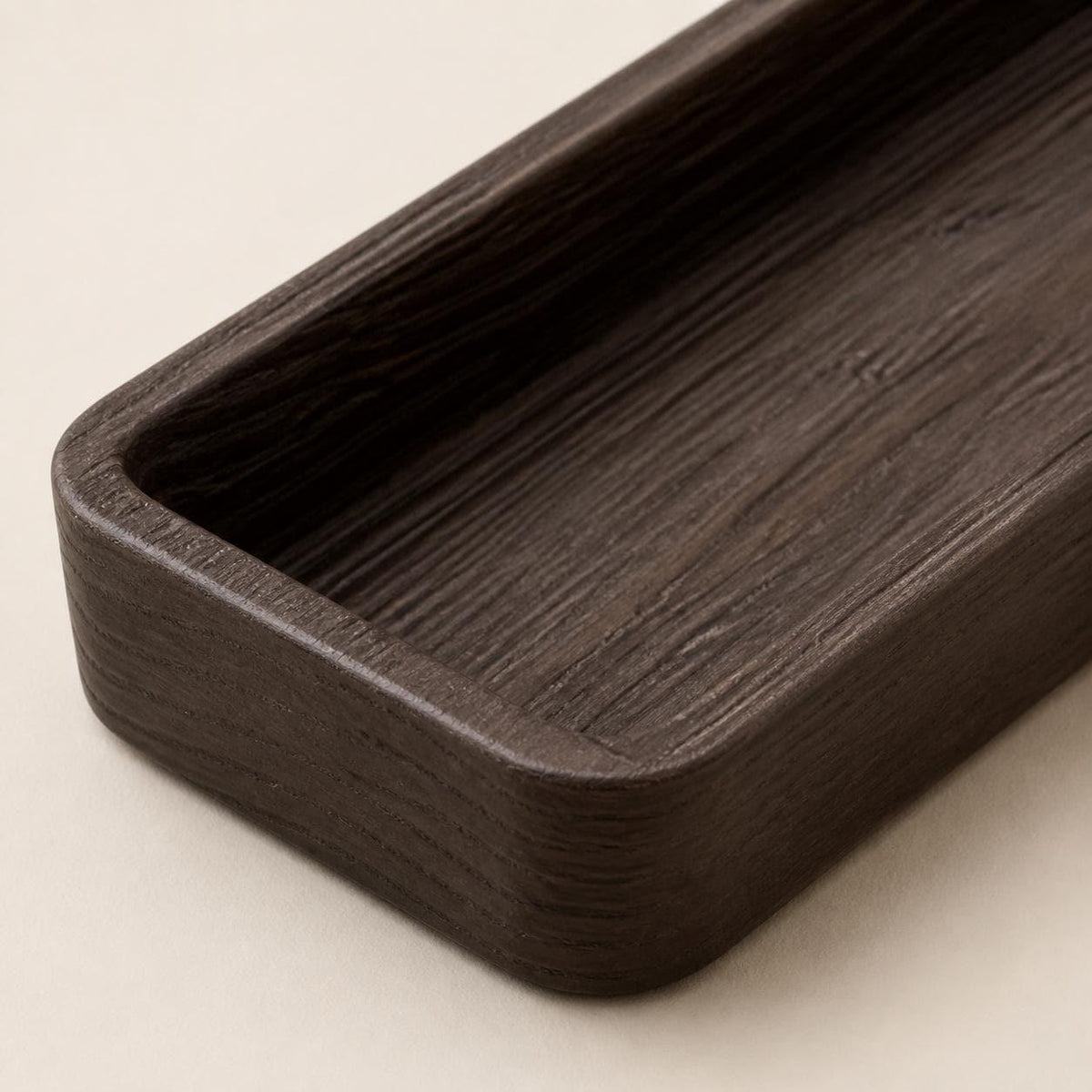 Embergrain Valet Tray, close-up of the Timberfold tray's continuous tactile grain across the rim walls and basin