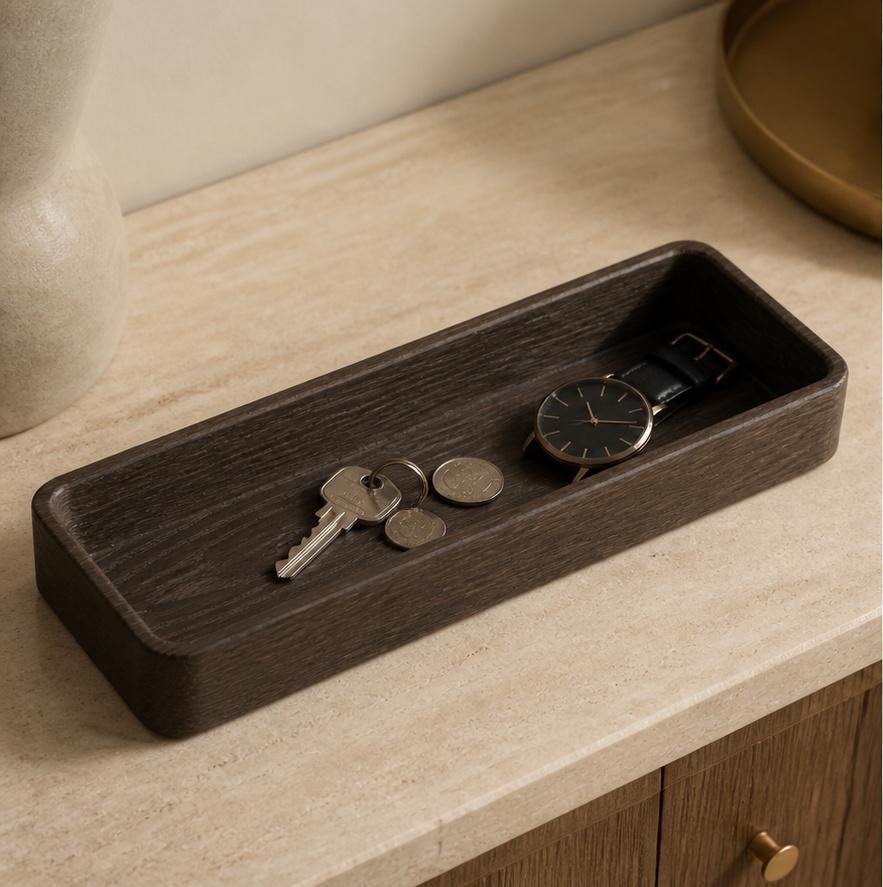 Embergrain valet tray in espresso brown, three-quarter close-up on an entryway console holding keys and a watch.