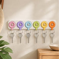 SpinKey Welcome Rail in a soft multicolor palette mounted near an entryway door with several button keychains docked.