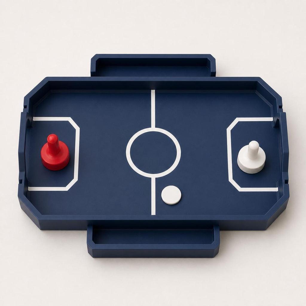 Near-overhead view of the Dark Blue RinkRush table hockey game with two attached catch trays, two pushers, and one Ivory White puck