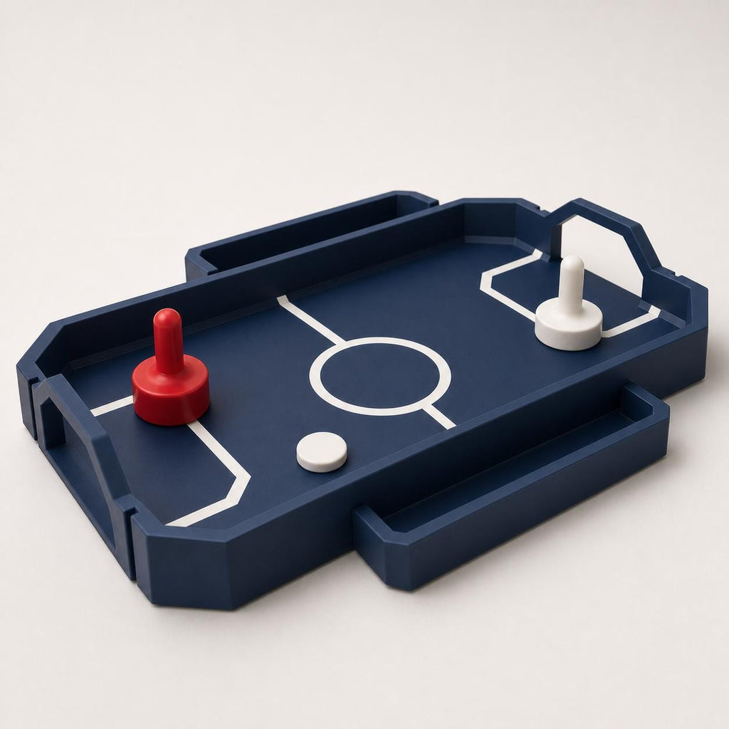 Rear-right close-up of the Dark Blue RinkRush table hockey game showing raised rails, angular goals, two pushers, and one puck