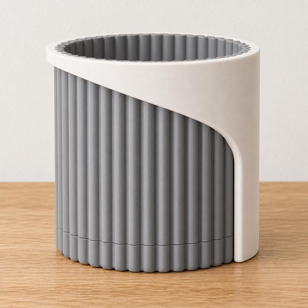Linen Shadow Arvenna planter with a Bone White smooth wrap and Ash Gray ribbed pot and matching drip tray on an oak tabletop.