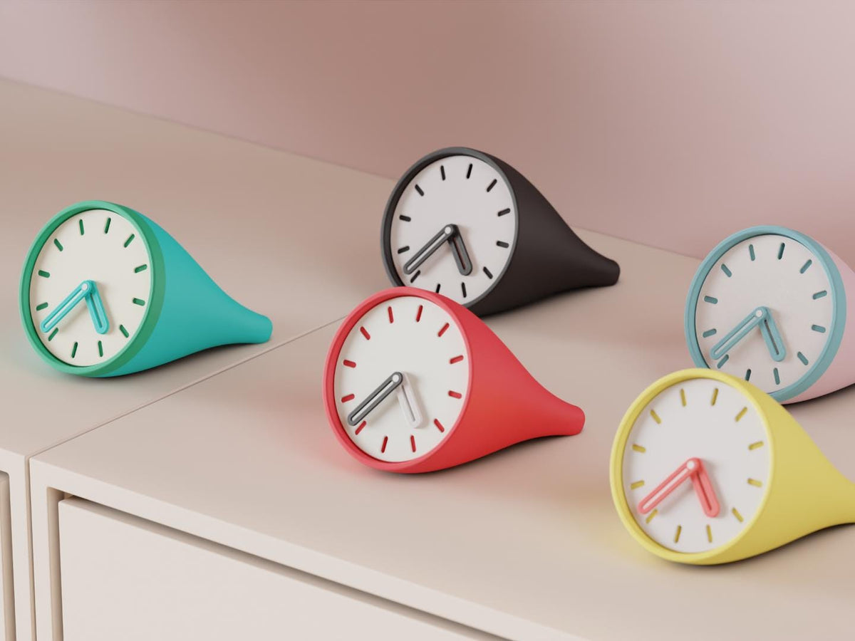 Fincrest Desk Clock examples in contrasting colors on a pale cabinet, showing the finished clock faces and hands.