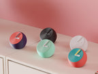 Pebblewave Spherical Desk Clock examples in contrasting colors on a pale cabinet, showing the finished clock faces and hands.