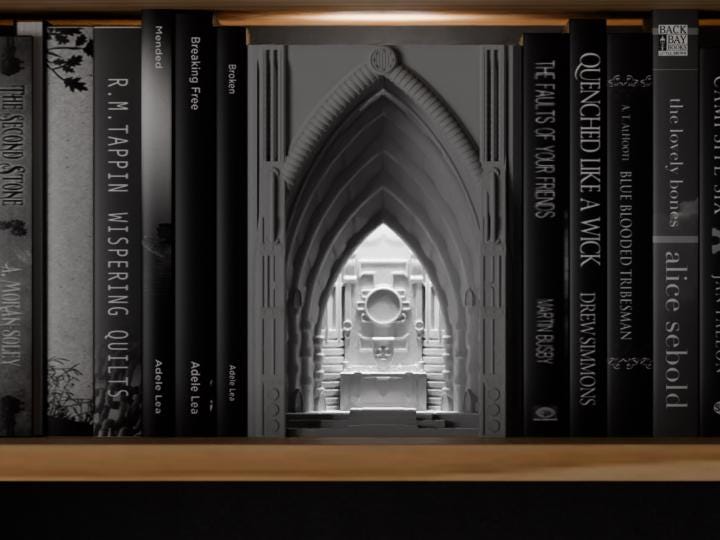 Ironvault Sanctuary Book Nook in a light neutral color, shown from the front between books on a wooden shelf.