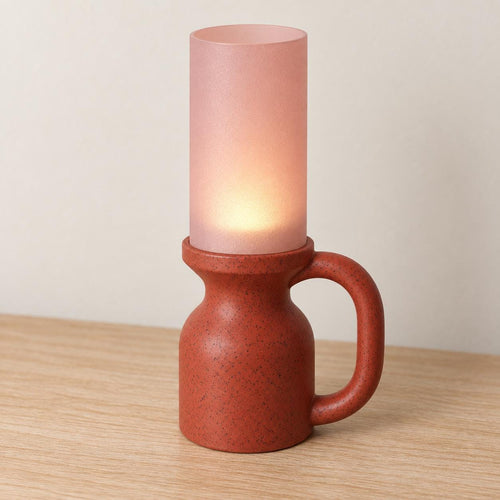 Elevated view of the Granite Blush Avelune lamp with a Red Granite speckled base and handle, open Cherry Pink shade and warm tea light glow.