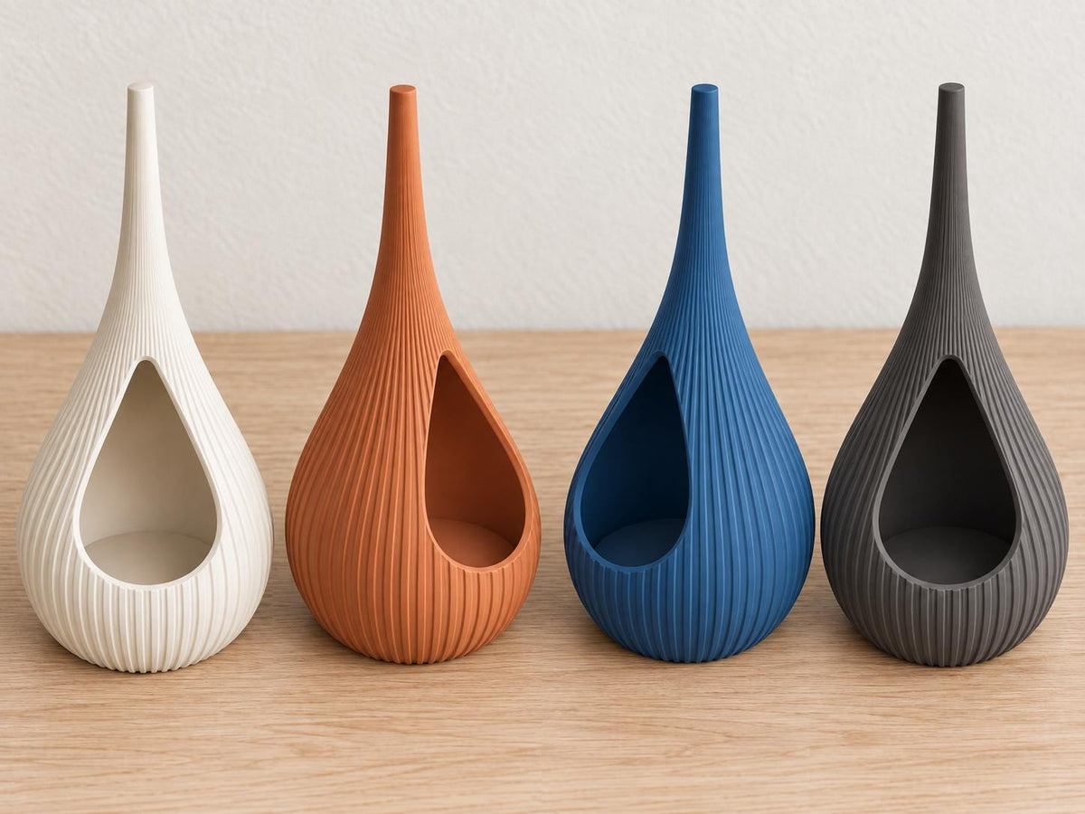 Elevated view of four empty Solenne holders in Ivory White, Terracotta, Marine Blue and Charcoal, with angled views of their open cavities.