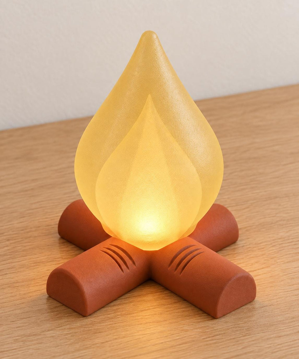 Elevated view of Golden Ember Emberkin with Mellow Yellow nested flame shades and a Terracotta log base, glowing with a battery tea light and no cord.